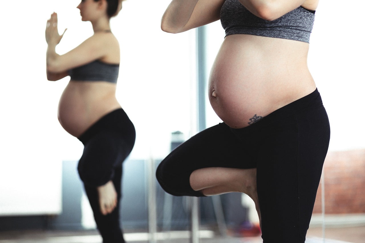 Femme enceinte faisant du yoga sur un pied