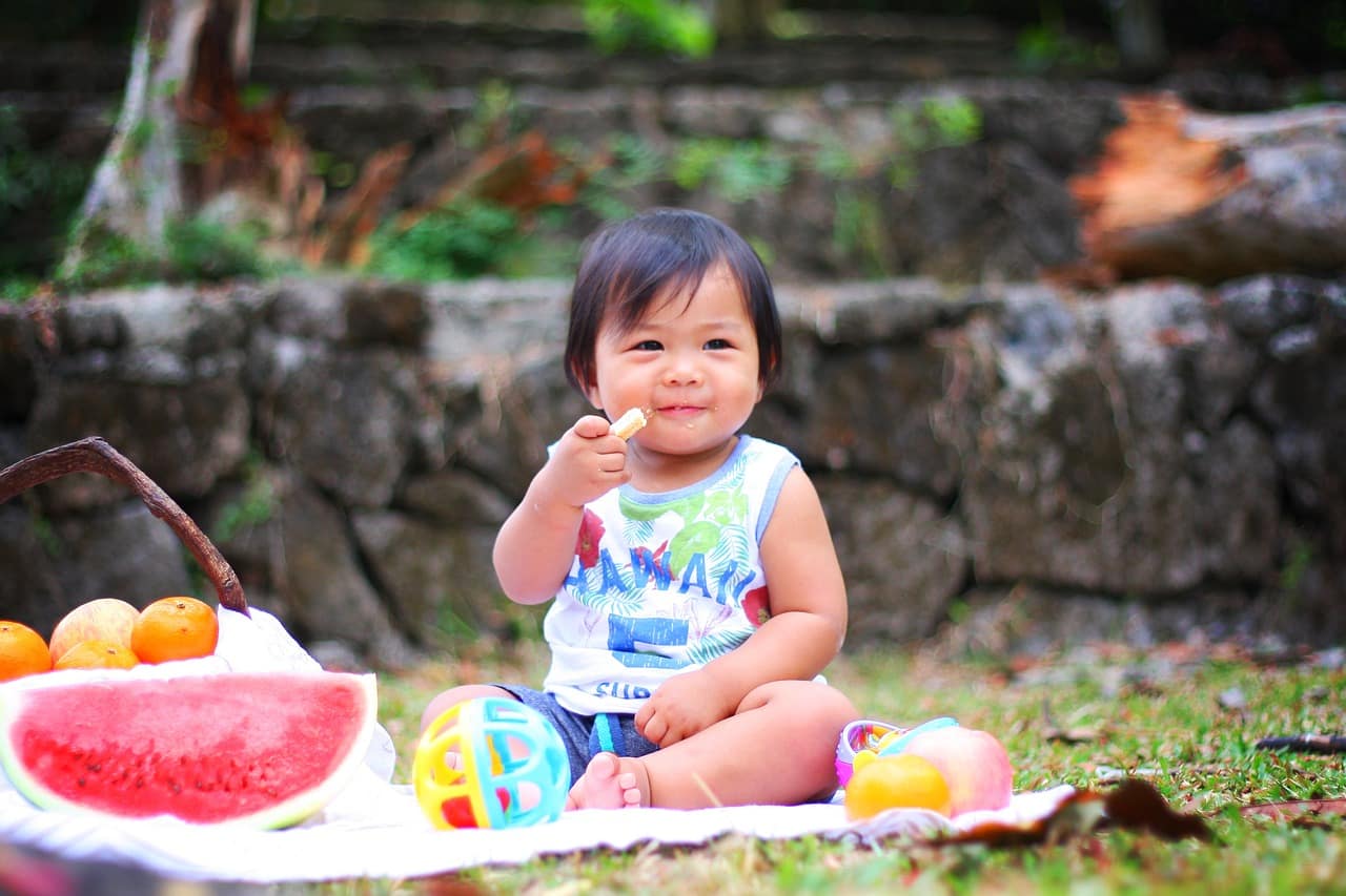 bébé qui mange des fruits dehors
