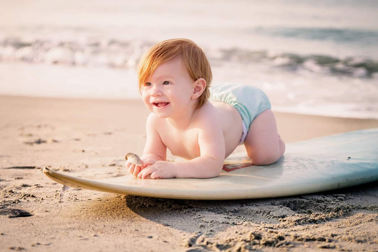 bébé sur une planche de surf à la plage